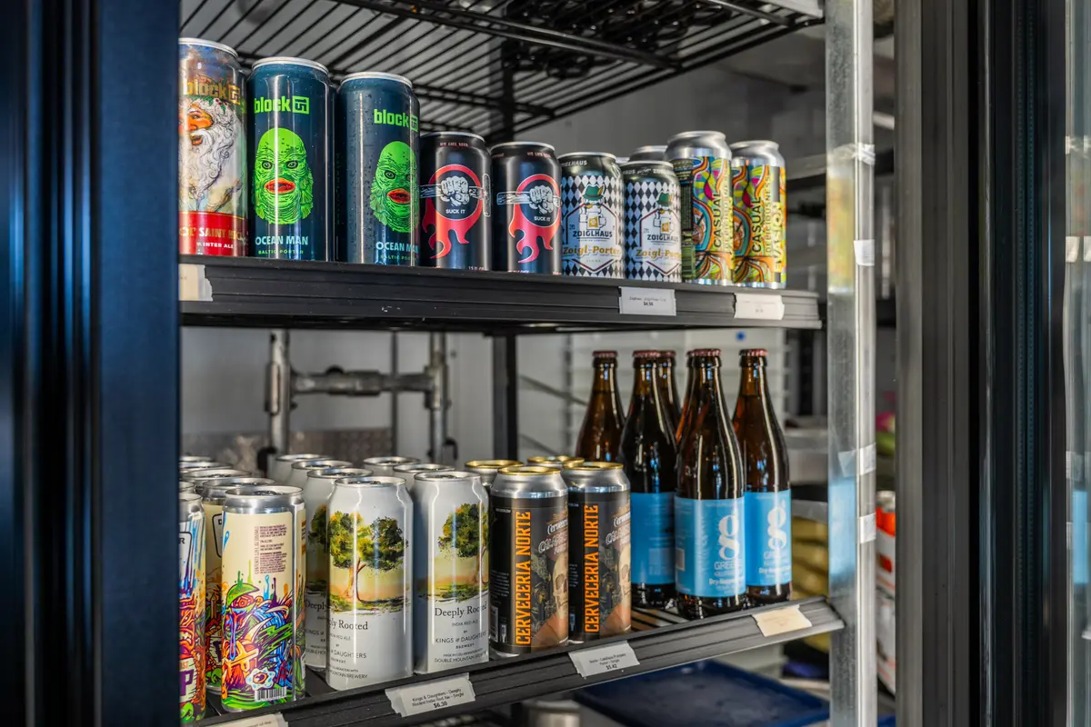 Fridge shelves of craft beer cans and bottles at Ballard Beer Box in Ballard, Seattle