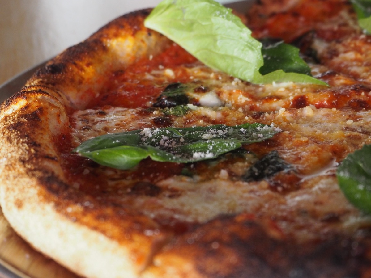 Close up of a margherita at Ballard Beer Box, the charred edge of the crust in focus
